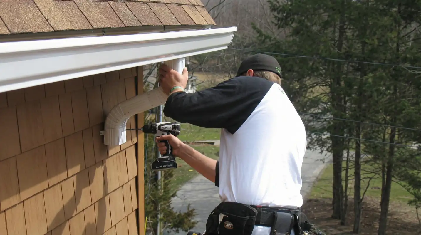 Professional contractor installing tan vinyl siding panels on a residential home exterior in Cleveland, OH